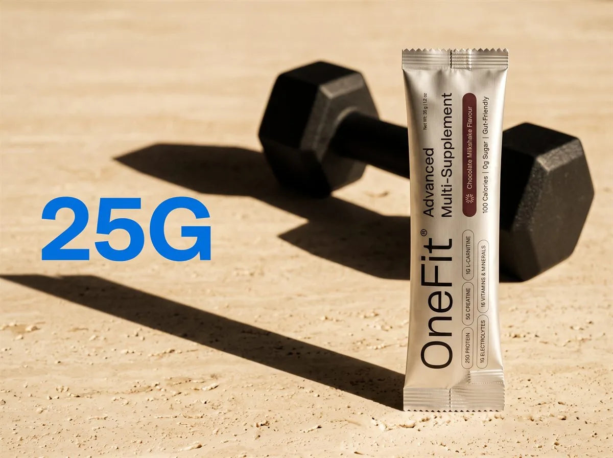 25g. A OneFit Chocolate Milkshake sachet standing beside a black dumbbell on warm stone in hard afternoon light