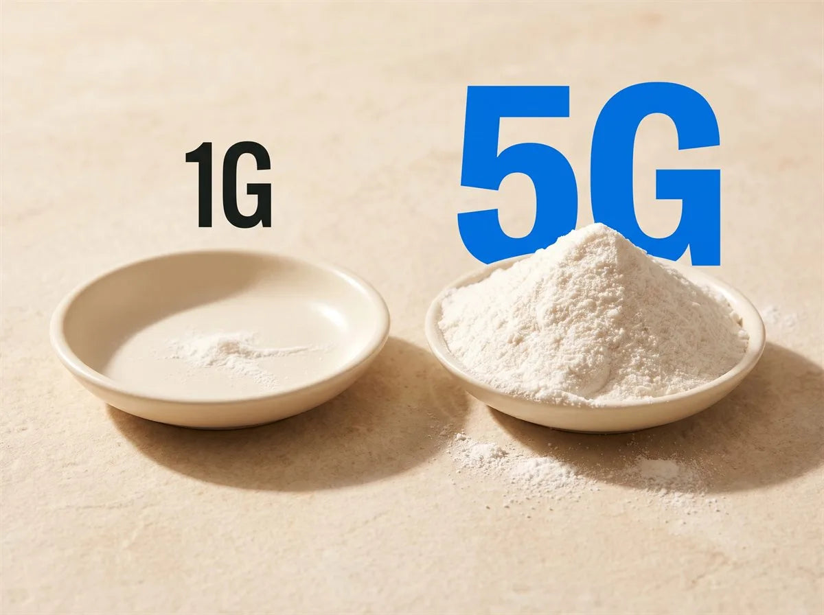 Dose compared, side by side on warm stone: a 1g pinch of creatine barely covering the bottom of one dish, beside a heaped 5g scoop in another