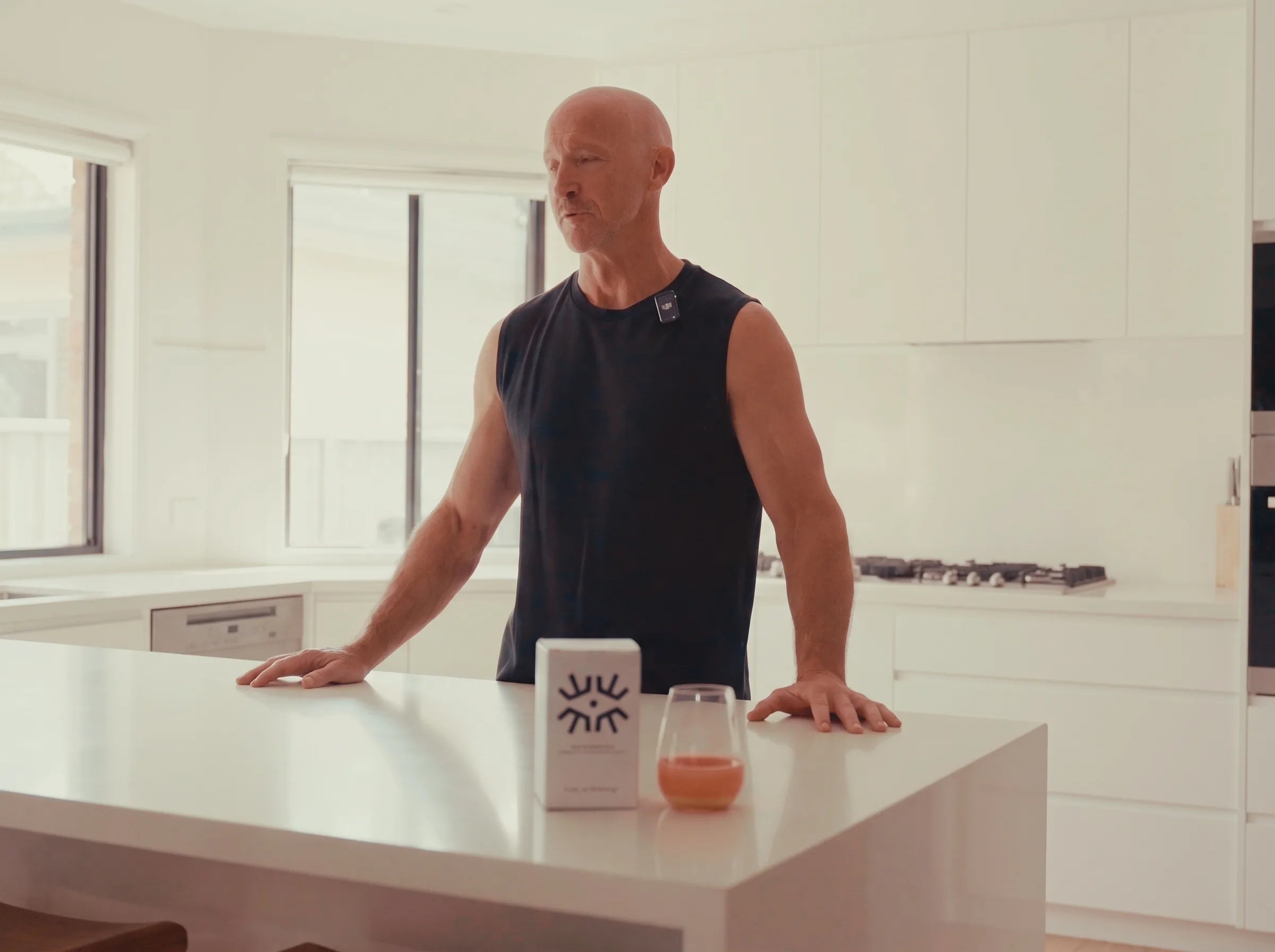 Darren standing at his kitchen island with the OneLife pack and his prepared watermelon serve on the bench in front of him