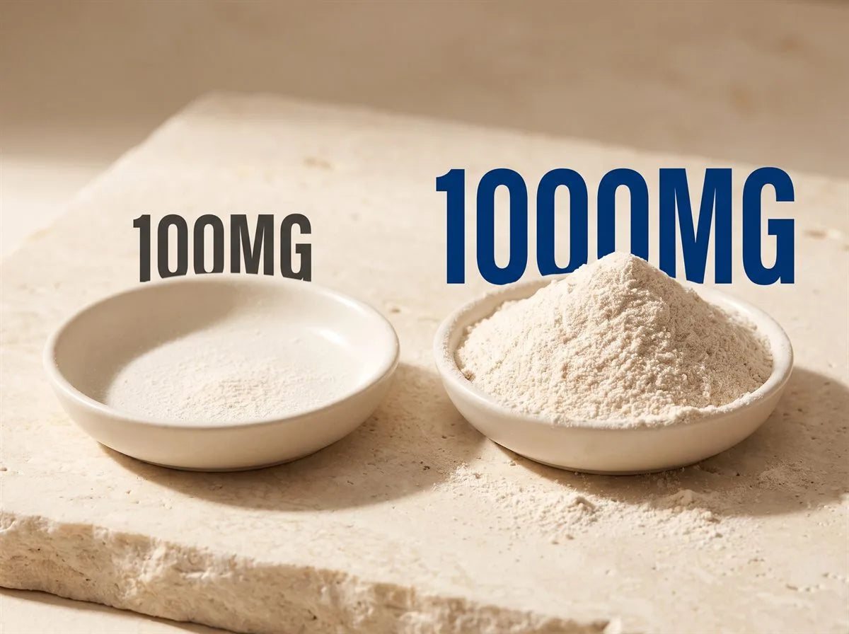 Dose compared on warm stone: a 100mg sprinkle of powder in one dish beside a heaped 1,000mg measure in another