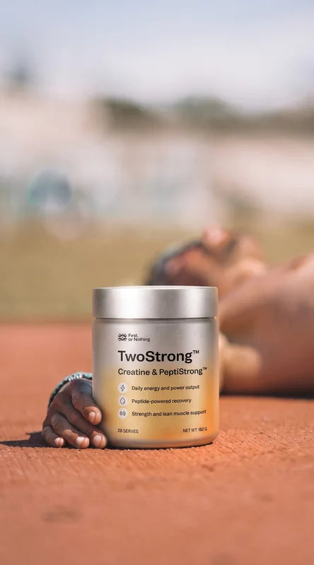 A jar of TwoStrong on a running track, an athlete resting behind it