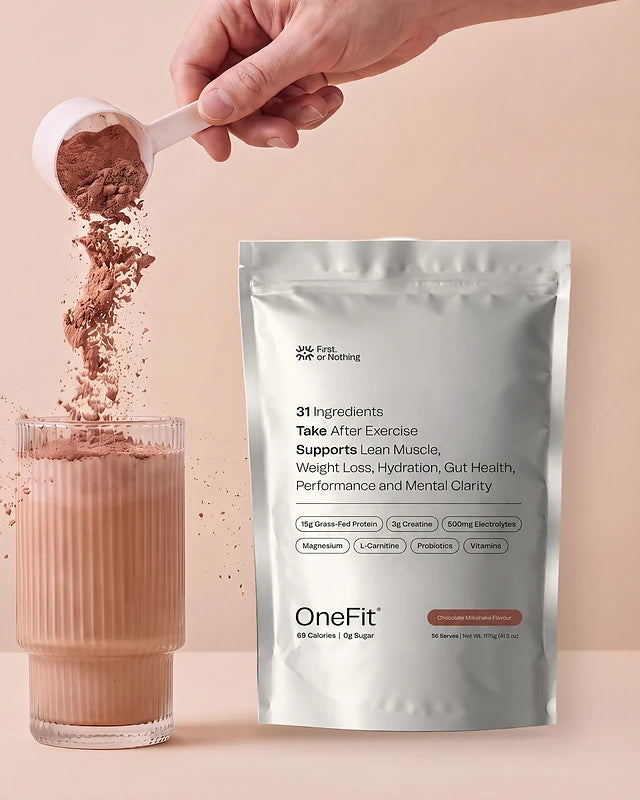 A scoop of OneFit Chocolate Milkshake poured into a glass beside the OneFit pouch